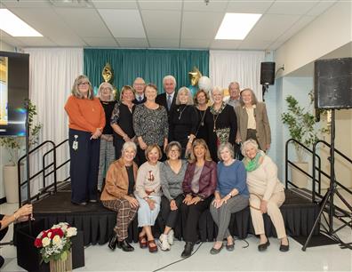 Group photo of event speakers and VIPs on stage.