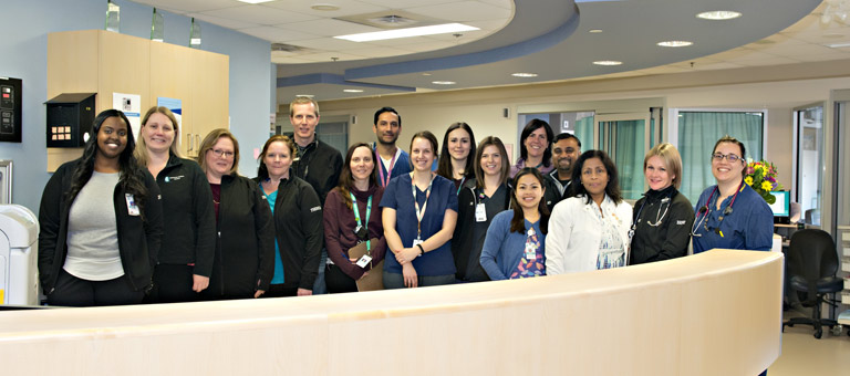 ICU team employees standing behind desk